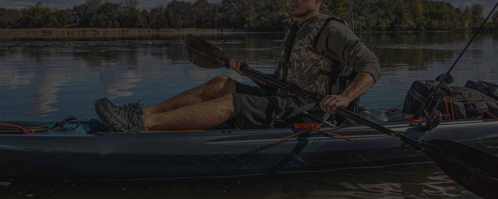 A man in a kayak with hunting gear and nice outdoor shoes