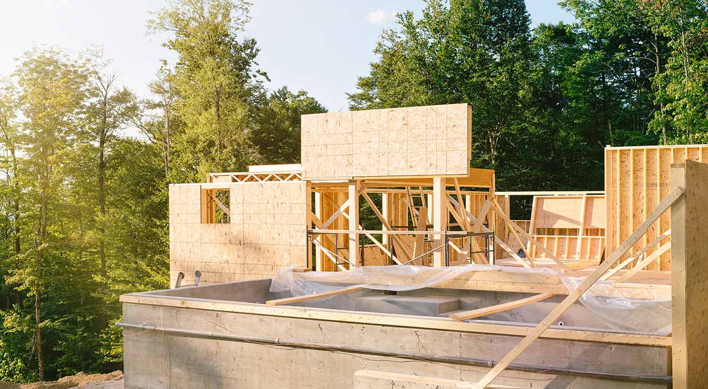 Residential construction site panorama with concrete pool in the foreground.